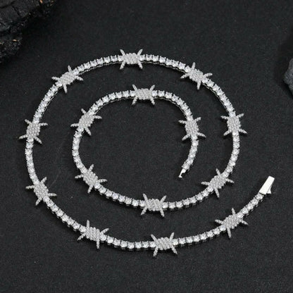 Collier tennis hip-hop premium en finition or blanc, serti de zircones AAAAA+ ultra brillantes. Design épine moderne, style iced-out luxe, longueur 45 cm.